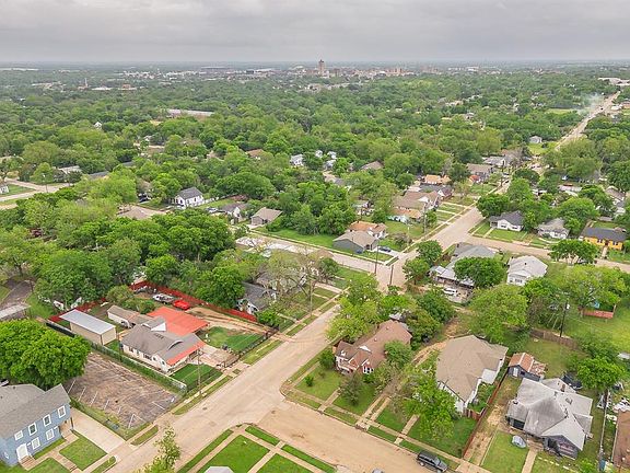Aerial view of the neighborhood with a mix of residential properties and mature trees