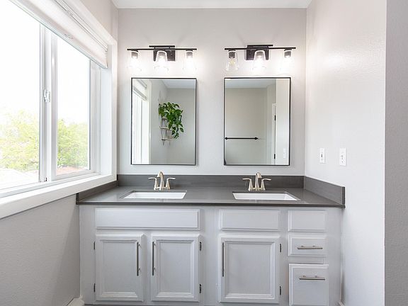 Remodeled bathroom featuring new windows, countertops, sinks, sink fixtures, tile, mirrors, paint and light fixtures - all updated in 2021