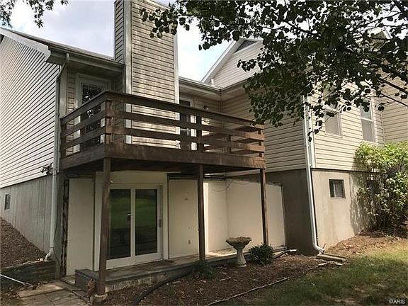 a view from the rear side yard illustrating the deck from the Great Room and the Sliding Atrium Doors from the Family Room to the patio under the cover of the deck.  The portion jutting out is the Master Bedroom Wing.