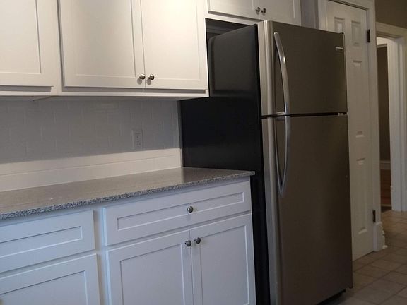 From the parking lot, there is a pantry next to the refrigerator.