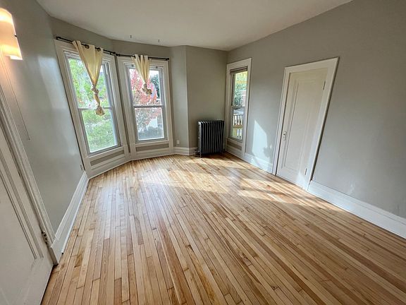 All bedrooms are very large. This one has a private balcony accessible through the righthand window, plus newly refinished maple hardwood floors and fresh paint!
