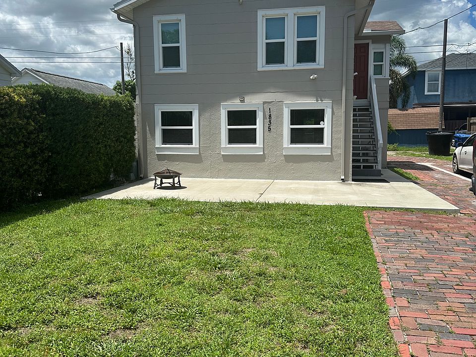 Front of apartment with brick drive and patio.