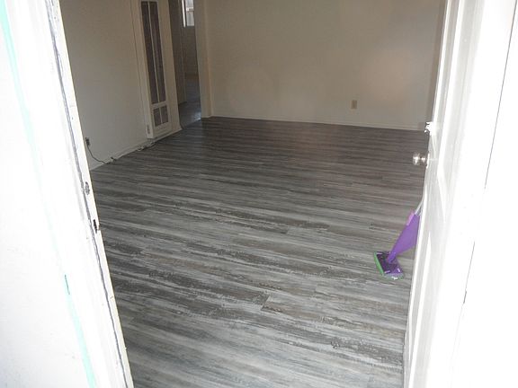 Living room with new flooring through front door.