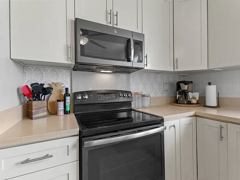 The kitchen is open to the living room and features plenty of storage and counter space, a ceiling fan, full size refrigerator with water station, oven, microwave and dishwasher. The kitchen is fully equipped.