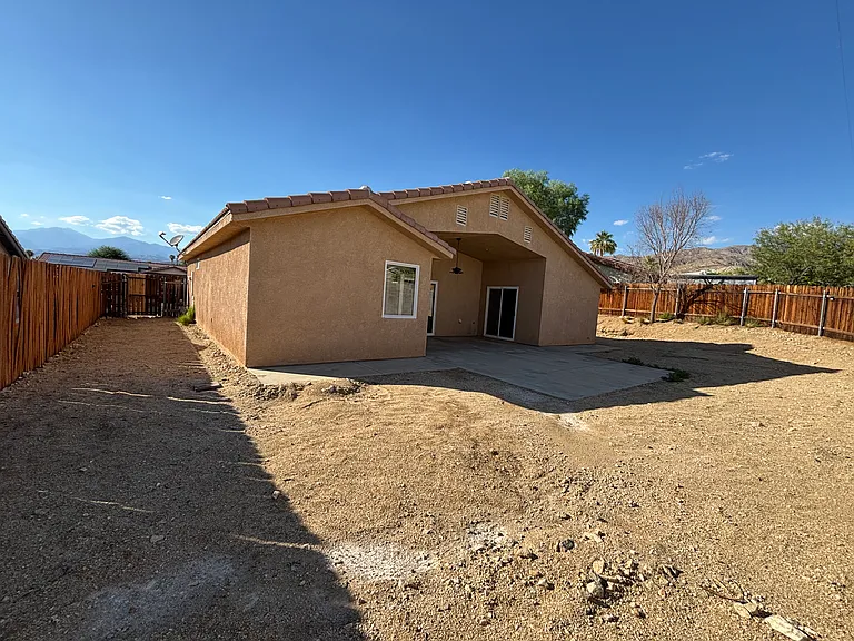 Large private fenced backyard with plenty of open space, plus a covered patio for outdoor seating and dining.