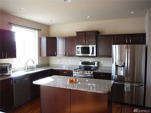 Large, open, sunny kitchen with granite counters, new stainless appliances, and large island.