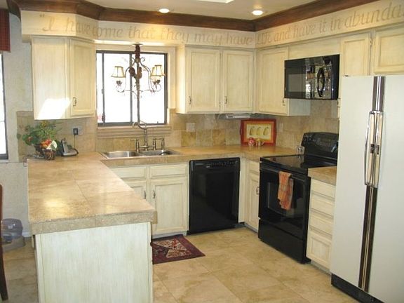 Sunny kitchen with tiled floors, counters and back splash and skylight
