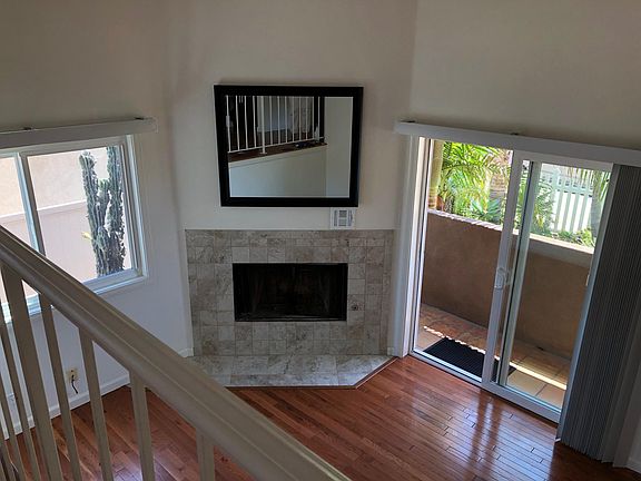 Downstairs living area showing fireplace, lower balcony, and yard. Fireplace is no longer usable.