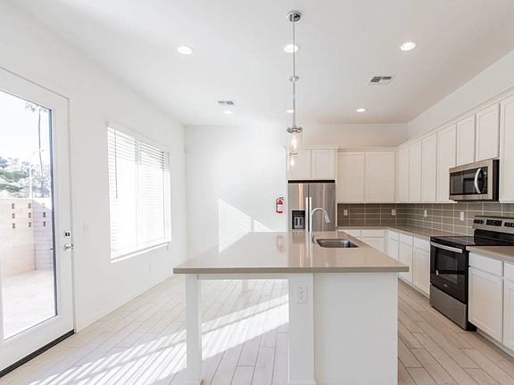 Beautiful, modern kitchen - this image was from when the townhome was new. It is now fully stocked and ready for move-in. There's also plenty of space for your own kitchen supplies.