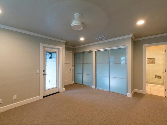 Master bedroom with dual closets and ceiling fan