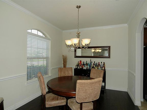 As you walk in the front door, the formal dining room is located to the left. The wood floors, chair rail, crown moulding and nice light fixture make this room luxurious!
