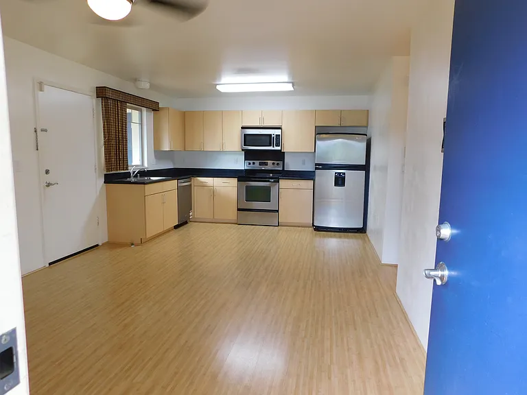 From front door. Wood laminate flooring. Stainless refrigerator with water and ice maker; range; microwave hood; dishwasher.