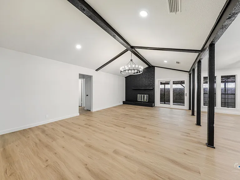 Doors to covered side patio and fireplace in living room