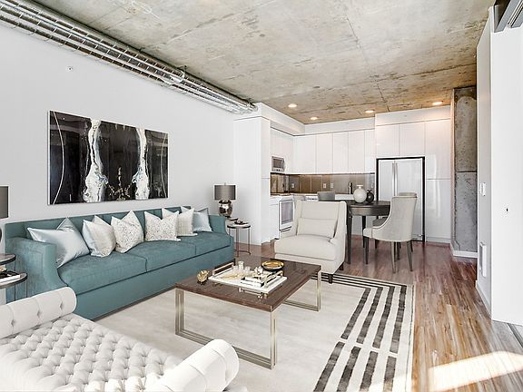 Staged, open concept apartment with hardwood style flooring.