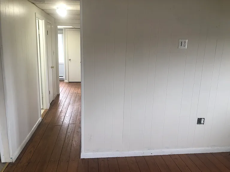 Kitchen/living room looking toward hallway leading to full bathroom and the 3 other rooms seen in other photos.