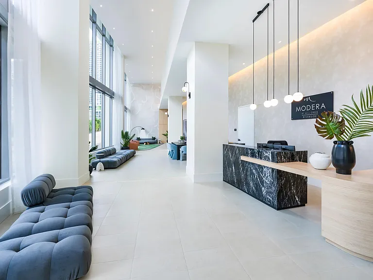 A warm welcome awaits at Modera Riverside's sophisticated lobby with modern design and natural light.