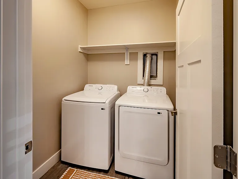 Laundry day just got easier with an energy-efficient washer and dryer, extra storage shelving, and stylish modern finishes.