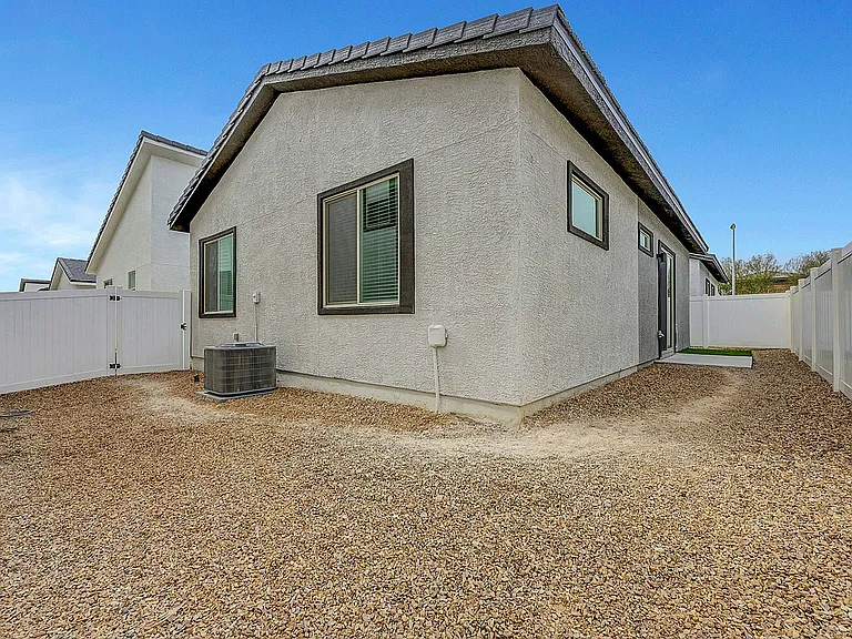Experience simplicity and elegance with this modern home's exterior, featuring a low-maintenance gravel yard.