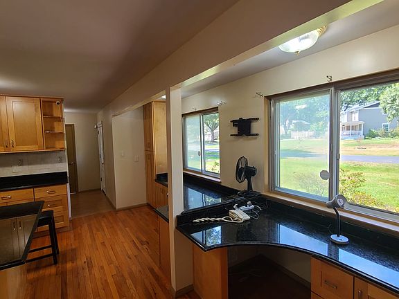 Kitchen with built in storage and desk area. Features large windows and natural sunlight.