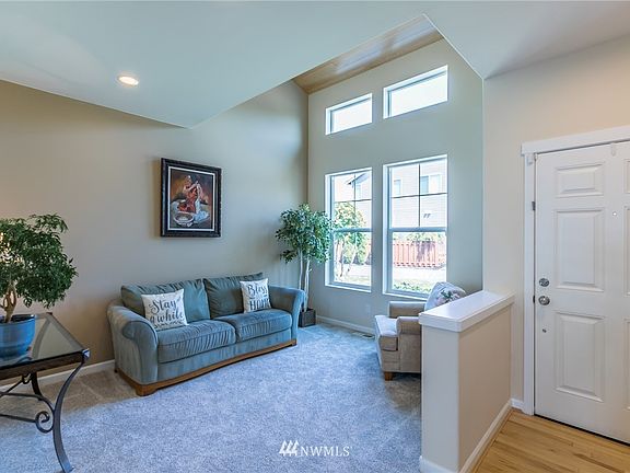 Living room off entry has vaulted ceiling, large windows
