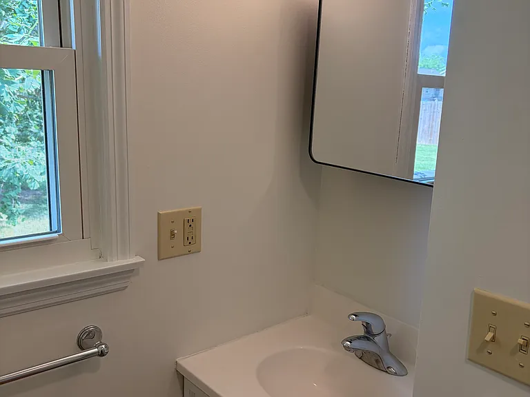 smaller full bathroom with new medicine cabinet and lighting