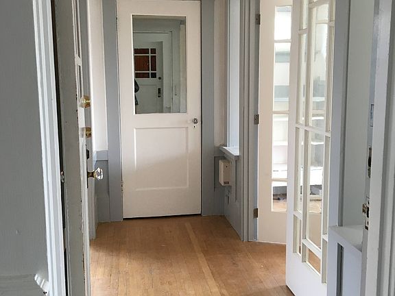 Entry hall with closet straight ahead and front room (flexible second bedroom, formal living room, home office and/or guest room) to the right