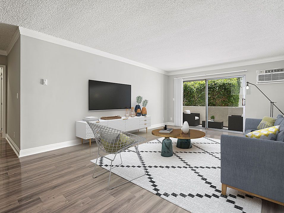 Large hardwood floored living room with access to private balcony.