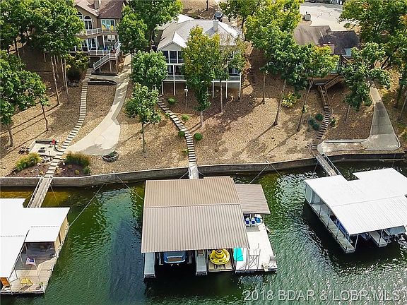 The property has 80 feet of shoreline, a newer dock with two boat slips including one which measures 17X46', custom bar with gra