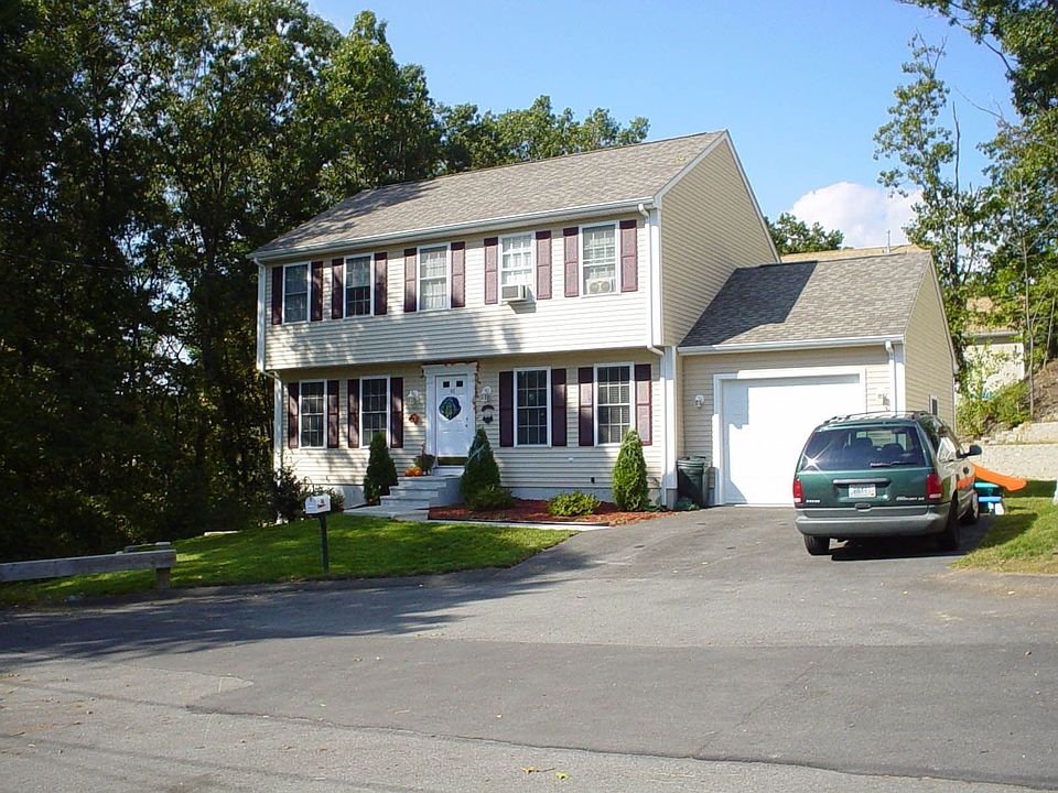 Front of our home. Notice the wooded space and extra parking area