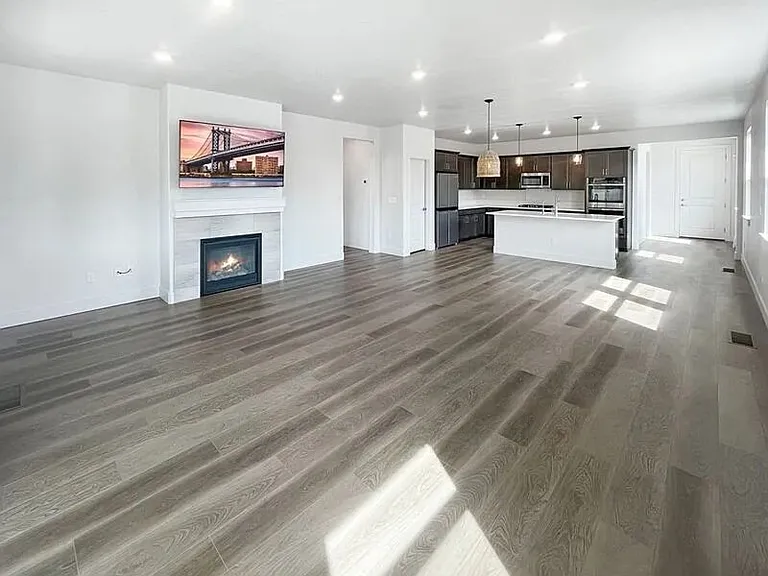 Bright living area with engineered hardwood flooring and gas fireplace