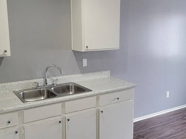 Kitchen with spacious white cabinets and large eating area at Grand Oaks Apartments in Lake Elsinore, California.