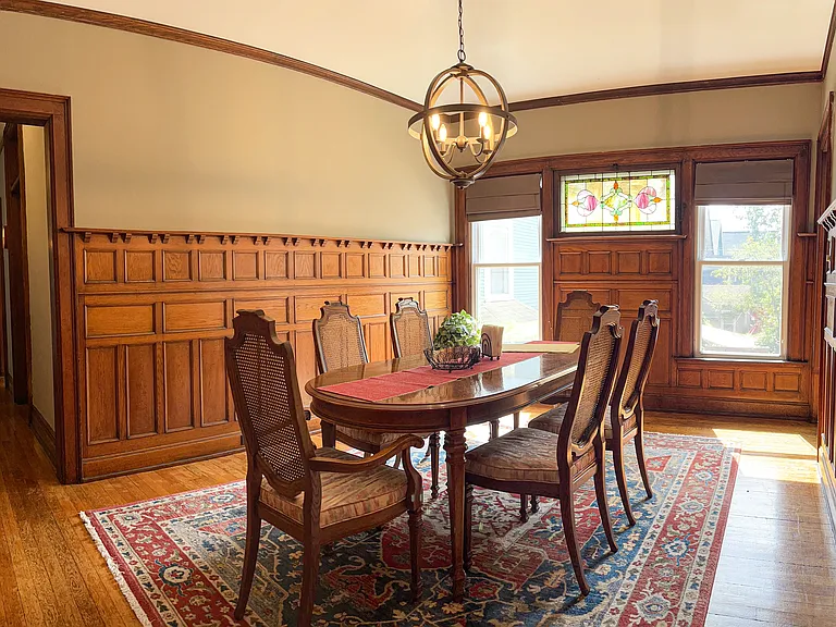 [Dining room] Features all-original wood paneling, and stained-glass window.