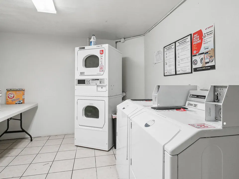 Laundry room with washing machines neatly arranged on a wooden floor