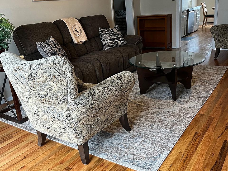 Living room with hardwood floor, new sofa and two comfortable chairs.