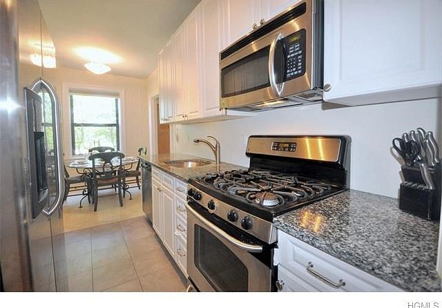 New Eat-in-Kitchen with granite counters and stainless steel appliances including a dishwasher, micr