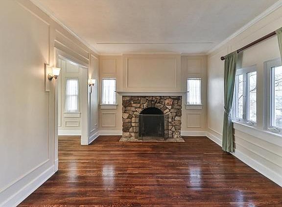 Living room with stone fireplace, detail molding and newly refinished wood floors