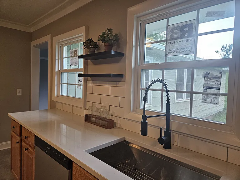 Kitchen with hardwood cabinets, lots of natural light, new quartz countertops and backsplash