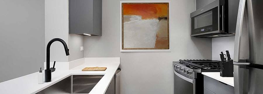 Finish Package II Kitchen with quartz countertop and backsplash, upgraded stainless steel appliances, and upgraded lighting
