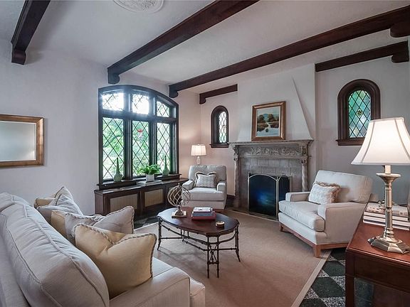 The sunken living room with terrazzo flooring, carved Italian mantelpiece, wood-beamed ceiling, and leaded-glass windows, as well as arched stained-glass windows.  Only the finest quality in this home!