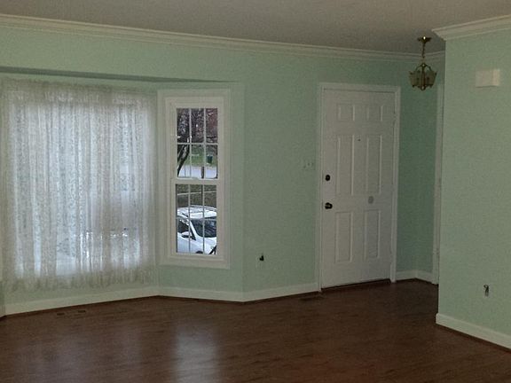 Middle floor: Living Room 18x14, natural lighted by a bay window. This view is from inside, looking at the front door. On the right side, there is a guest closet and the powder room. Cables are run through the walls.