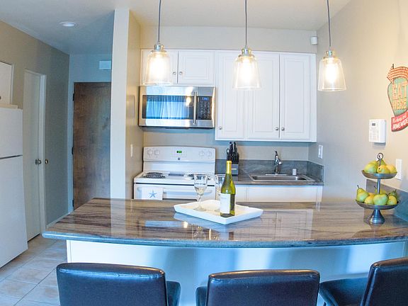 White door next to refrigerator is for 1/2 bathroom and brown door is entry.