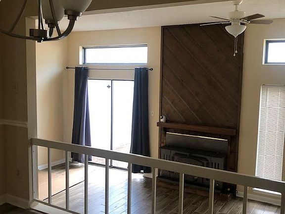 View of living room with fireplace from dining room