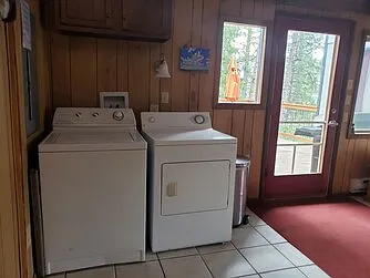 Entry room washer/dryer next to full bathroom, door to deck, tile floor, armoire, large closet