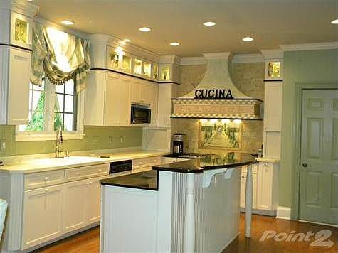 The kitchen is very open and the hub of the home.  There is a center island with granite counter, stainless steel six burner Dacor range, stainless steel Sub Zero refrigerator, two full ovens and custom Mouser cabinetry.