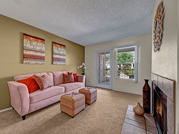 A living room with fireplace and glass door out to the patio