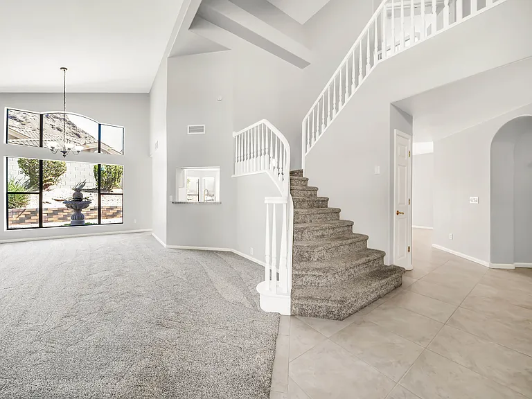 Open staircase to two of the four bedrooms. The spacious master and mini master suite are upstairs