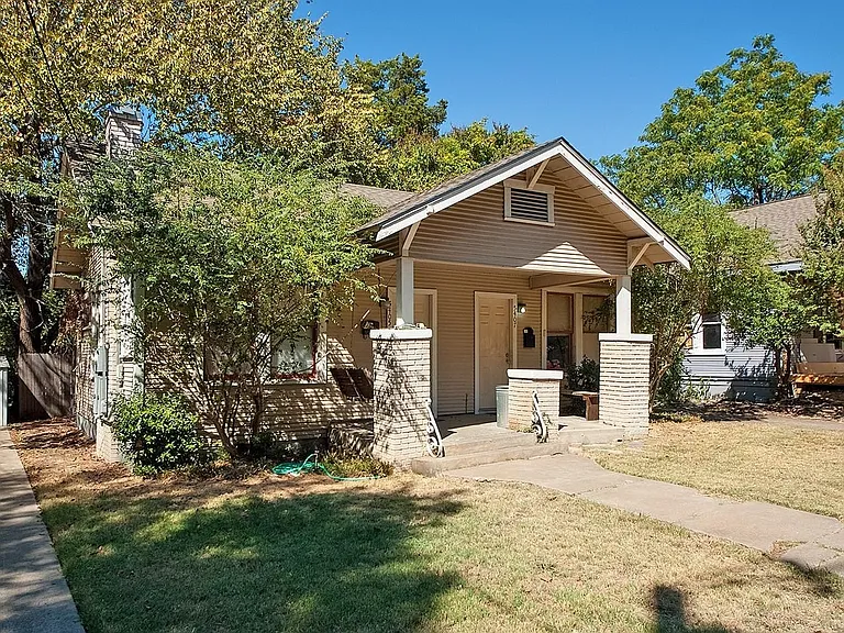 A cozy house with a charming front porch and a well-kept yard, creating a warm and inviting atmosphere.
