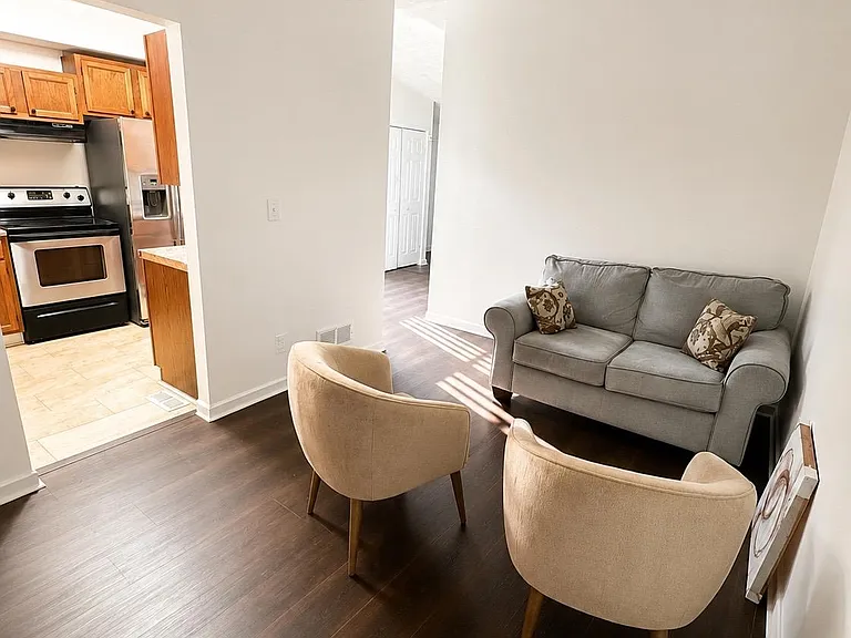 Living area with durable flooring and a comfortable seating layout, with easy access to the adjacent kitchen.