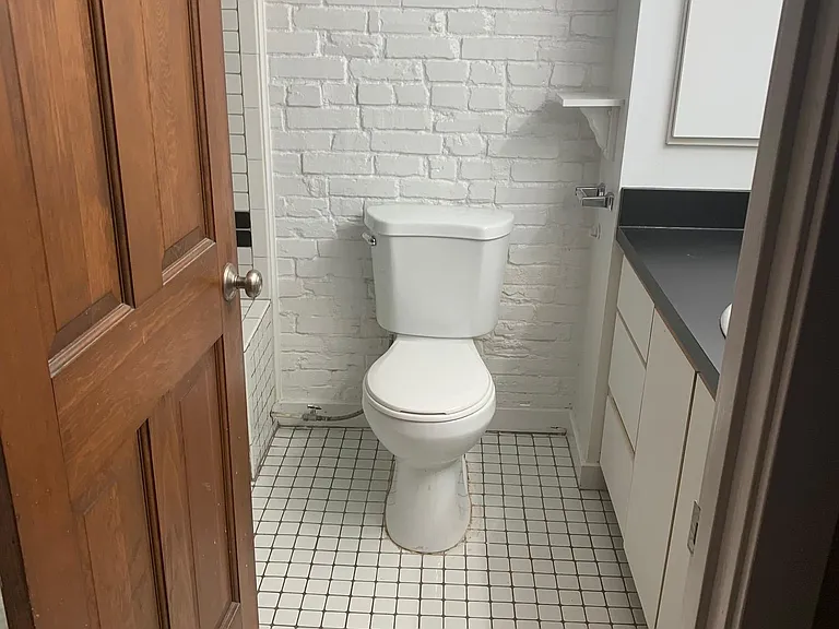 Bathroom with exposed brick