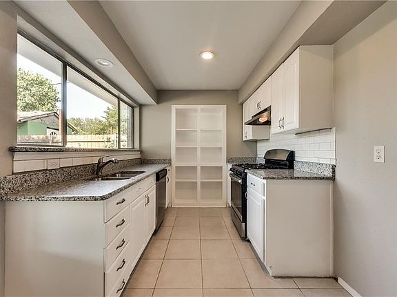 Nicely updated kitchen has picture window looking into the backyard, updated countertops & SS appliances.